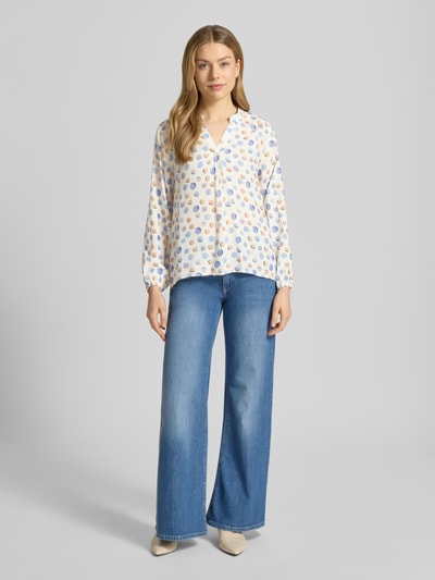 Frauenmodel trägt Regular Fit Bluse aus reiner Viskose Modell 'Josy' von ZABAIONE mit buntem Tupfenmuster, Tunika-Kragen, elastische Ärmelabschlüsse, leichte Textur, Ganzkörperansicht von vorne.