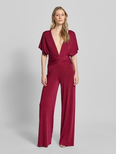 Vrouwenmodel draagt 'Jumpsuit mit rückseitig gekreuzten Trägern' van Rose Avenue in wijnrood, regular fit, diepe V-hals, soepel vallende stof, volledige lichaamsaanzicht van voren. Context: dames jumpsuit, ruglengte 120 cm, borstwijdte 50 cm, totale lengte 120 cm, binnenbeenlengte 92 cm.