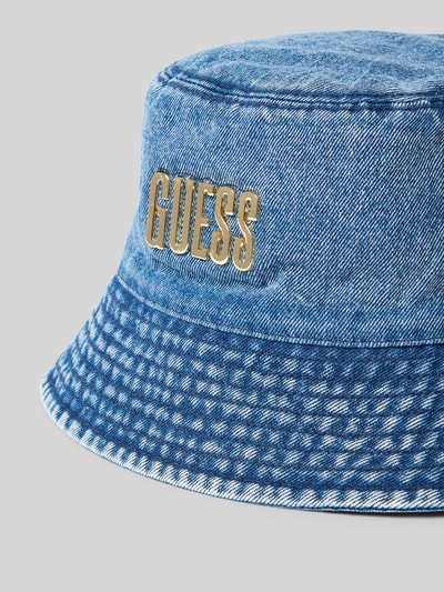 Produktfoto, Hut in Denim-Optik mit Label-Applikation von Guess aus reiner Baumwolle mit Krempe für Damen, blaue Farbe, strukturierte Oberfläche.