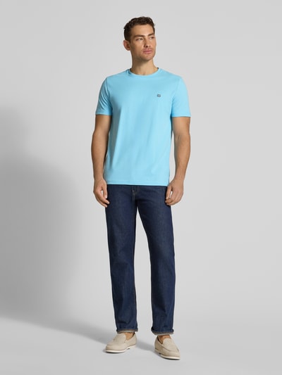Männermodel trägt T-Shirt aus Baumwolle mit Rundhalsausschnitt von Christian Berg Men in Hellblau, Regular-Fit, Label-Detail, Ganzkörperansicht von vorne.