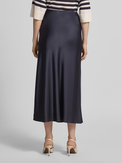 Frauenmodel trägt Midirock in schimmerndem Design von comma, glatter Stoff in Dunkelblau, gerader Schnitt, Ganzkörperansicht Rückansicht.