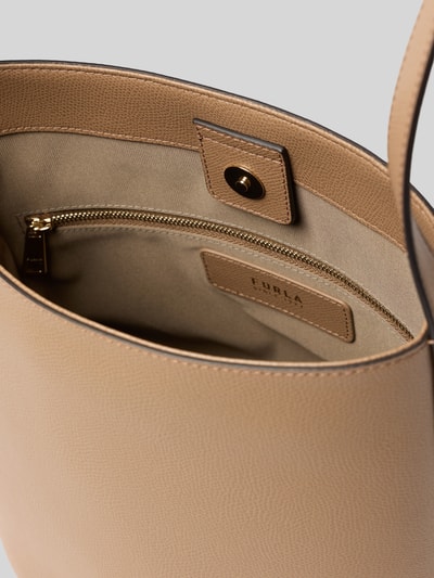 Produktfoto, beżowa torebka typu bucket bag Bucket Bag mit Logo-Applikation Modell 'Roxie' von FURLA z aplikacją z logo, główna przegroda z zapięciem na magnes, regulowany pasek na ramię, przegródka zapinana na zamek błyskawiczny po wewnętrznej stronie, szerokość w rozmiarze 1: 24 cm, długość w rozmiarze 1: 26 cm, głębokość w rozmiarze 1: 17 cm, długość paska na ramię w rozmiarze 1: 67 cm