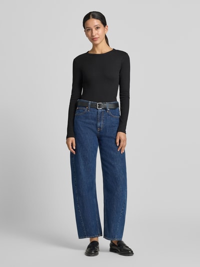 Frauenmodel trägt schwarzes Slim Fit Langarmshirt aus Baumwoll-Mix Modell 'CHLOE' von VERO MODA zu blauen Jeans, Ganzkörperansicht von vorne. Damen Langarmshirt von VERO MODA.