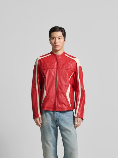 Männermodel trägt Regular Fit Jacke in Leder-Optik von Diesel in Rot mit beigefarbenen Akzenten, Logo-Stitching und Reißverschlusstaschen, Ganzkörperansicht von vorne.