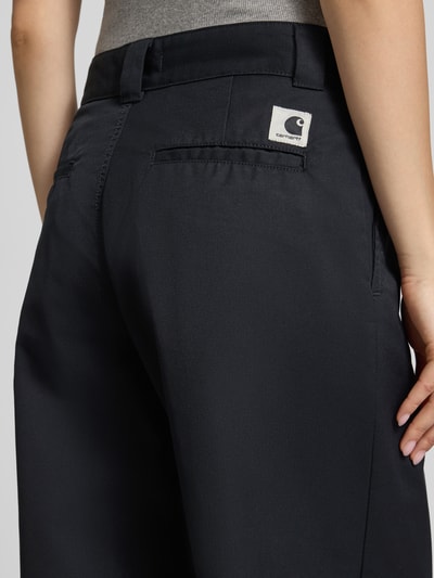 Frauenmodel trägt Loose Straight Fit Hose mit Eingrifftaschen von Carhartt Work In Progress im Material-Mix, dunkel, Detailaufnahme Rückansicht.