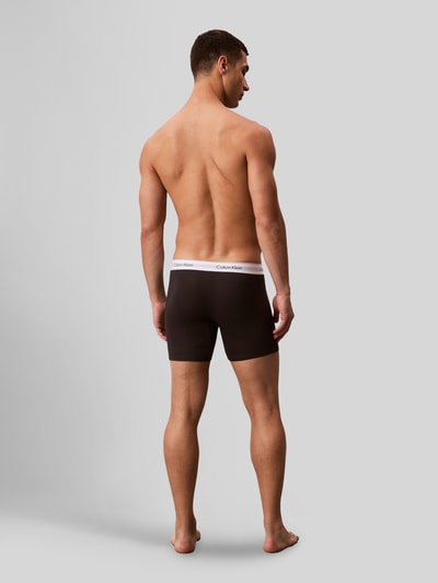 Männermodel trägt Pant & Trunk mit elastischem Label-Bund im 3er-Pack von Calvin Klein Underwear, Schwarz, Baumwoll-Elasthan-Mix, Ganzkörperansicht Rückansicht.