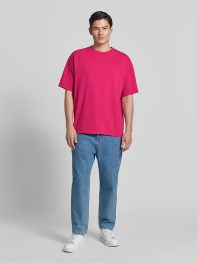 Männermodel trägt T-Shirt mit geripptem Rundhalsausschnitt Modell 'FIZVALLEY' von American Vintage in Pink, Reine Baumwolle, Loose-Fit, Ganzkörperansicht von vorne, Rückenlänge bei Größe M/L 72 cm.