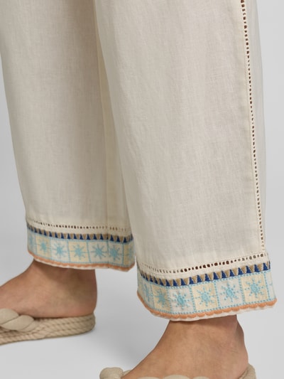 Vrouwenmodel draagt Culotte aus Leinen-Baumwoll-Mix mit Eingrifftaschen van Jake*s Casual, lichtbeige met blauwe en oranje randdetails, straight fit, elastische taille met koordsluiting, Franse steekzakken, detailopname onderbeen.