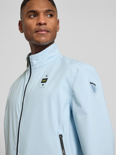Männermodel trägt Jacke mit Label-Patches Modell 'Anson' von Blauer Usa in Hellblau mit Stehkragen, Nahaufnahme Oberkörper.