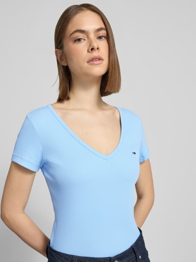Vrouwenmodel draagt Slim Fit T-shirt uit katoenmix van Tommy Jeans met look: effen kleuren, gestikt logo, V-hals, korte mouw, jersey materiaalverwerking, Nahaufnahme Oberkörper