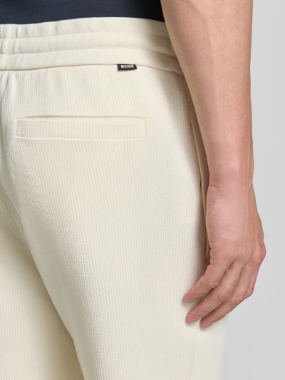 Männermodel trägt Regular Fit Stoffhose aus reiner Baumwolle Modell 'C-LEVETE 55' von BOSS in Optik: Unifarben, Strick, Nahaufnahme Rückansicht.