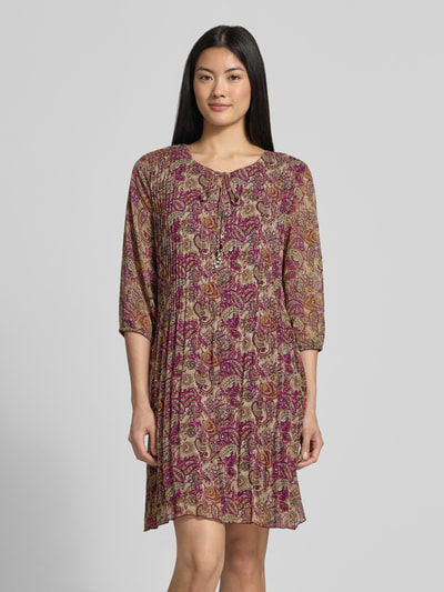 Frauenmodel trägt Knielanges Kleid mit Schlüssellochausschnitt von ZABAIONE in Falten-Optik, gemustert in Violett, Beige und Gelb, Relaxed Fit, Halbarm, Ganzkörperansicht von vorne. Rückenlänge bei Größe S 93 cm, Brustweite 47 cm, Ärmellänge 44 cm.