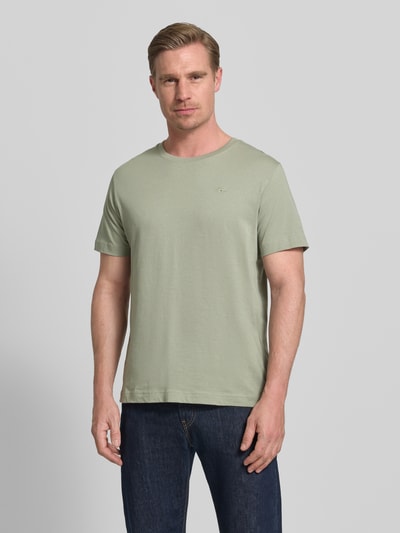 Męski model nosi Regular Fit T-Shirt aus reiner Baumwolle von Tom Tailor, efekt: jednolity kolor, krój regular fit, wyhaftowane logo, okrągły dekolt, krótki rękaw, wykończenie materiału: dżersej, bawełna, Ganzkörperansicht von vorne.
