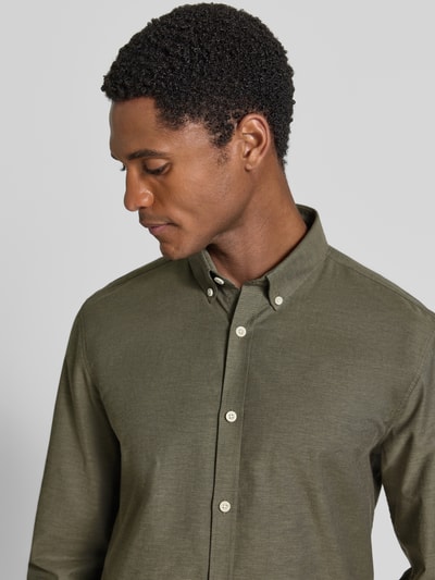 Männermodel trägt Regular Fit Freizeithemd aus Baumwoll-Mix Modell 'Oxford' von Lindbergh in Olivgrün, Nahaufnahme Oberkörper. Herrenhemd mit Button-Down-Kragen, 1-Knopf-Manschetten, abgerundetem Saum, Rückenlänge 77 cm, Schulterbreite 44 cm, Ärmellänge 66 cm.