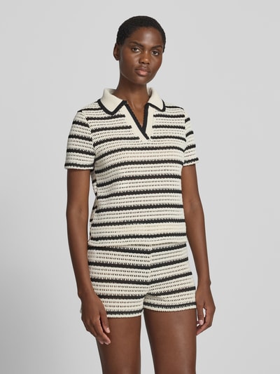 Frauenmodel trägt Strickshirt mit Polokragen Modell 'MIFFY' von MANGO, creme-schwarz gestreift, V-Ausschnitt, Ganzkörperansicht von vorne