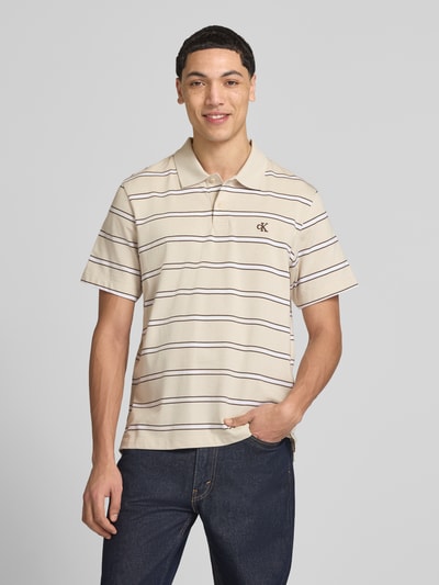 Männermodel trägt Regular Fit Poloshirt mit Logo-Stitching von Calvin Klein Jeans in Beige mit feinen Streifen aus Reine Baumwolle, Ganzkörperansicht von vorne.