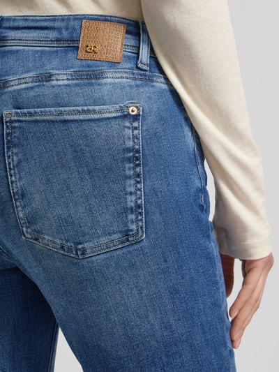 Frauenmodel trägt Flared Jeans mit Fransen Modell 'VIC' von Raffaello Rossi aus Baumwoll-Mix mit Stretch-Anteil, Nahaufnahme Rückansicht.