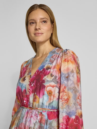 Frauenmodel trägt Cocktailkleid mit Bindegürtel von V by Vera Mont, farbenfroher Allover-Look, V-Ausschnitt, Taillierter Schnitt, Nahaufnahme Oberkörper. Rückenlänge bei Größe 36: 113 cm, Brustweite bei Größe 36: 31 cm, Ärmellänge bei Größe 36: 57 cm.