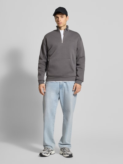 Männermodel trägt Sweatshirt mit Label-Print von REVIEW in Grau, Baumwoll-Mix, Lockerer-Schnitt, Känguru-Tasche, Ganzkörperansicht von vorne.