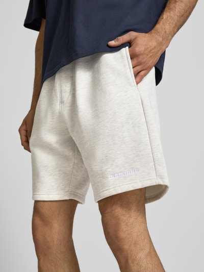 Männermodel trägt Regular Fit Shorts mit Logo-Stitching von Pegador aus Baumwoll-Mix, helle Farbe, elastischer Bund, Nahaufnahme Oberschenkel.
