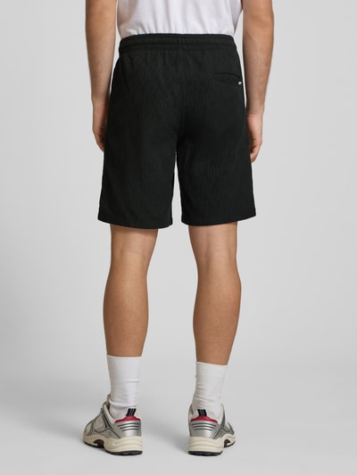 Männermodel trägt Shorts mit Strukturmuster Modell 'JAIDEN' von Jack & Jones, Material-Mix, Regular-Fit, Ganzkörperansicht Rückansicht.
