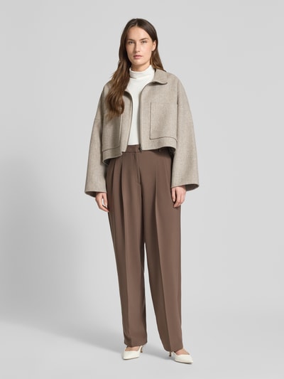 Frauenmodel trägt Wide Fit Stoffhose mit Gesäßtaschen Modell 'Emilie' von Cambio in Braun, Bügelfalten, Ganzkörperansicht von vorne.