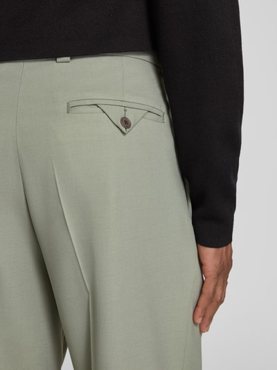 Männermodel trägt Modern Fit Anzughose von HUGO in hellem Grün, unifarben, mit Bügelfalte und Gesäßtasche, Nahaufnahme Rückansicht.