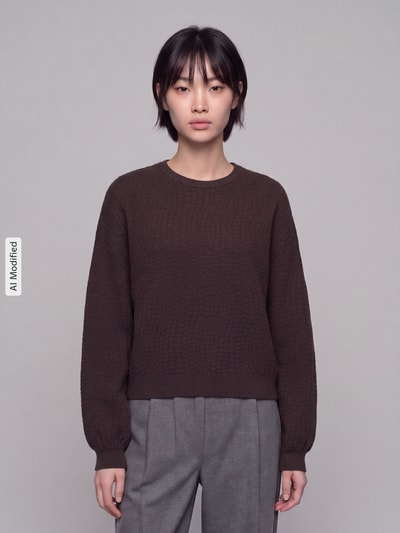 Frauenmodel trägt dunkelbraunen Regular Fit Pullover aus Viskose-Mix Modell 'NANCY' von VERO MODA, dezente Kachelstruktur, Ganzkörperansicht von vorne, KI-modifiziertes Bild.