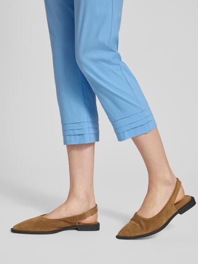 Mädchen trägt Caprihose aus Viskose-Mix Modell 'Ina' von STEHMANN, błękitny kolor, krój slim fit, drapowania, Szerokość w rozmiarze 36: 38 cm, długość nogawki wewnętrznej 59 cm, Ganzkörperansicht von vorne