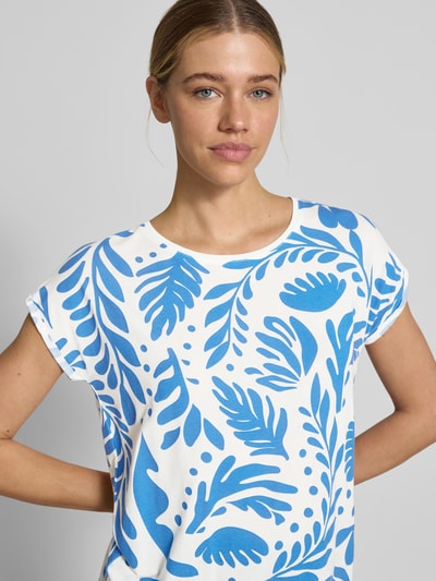 Frauenmodel trägt Relaxed Fit T-Shirt aus Lyocell-Mix Modell 'AVA' von Vero Moda mit Optik:Allover-Muster, Blattmuster, Rundhals, Kurzarm, Jersey, in Weiß-Blau, Nahaufnahme Oberkörper.