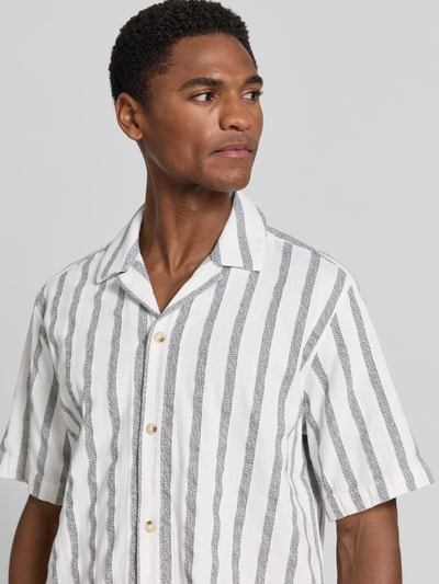 Männermodel trägt Regular Fit Freizeithemd aus reiner Baumwolle von Tom Tailor mit weißen und grauen Streifen, Nahaufnahme Oberkörper.