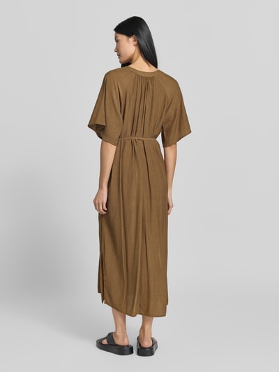 Frauenmodel trägt Relaxed Fit Freizeitkleid aus Viskose-Mix von s.Oliver RED LABEL in Braun, lockere Passform, mittellanger Schnitt, Ganzkörperansicht Rückansicht.