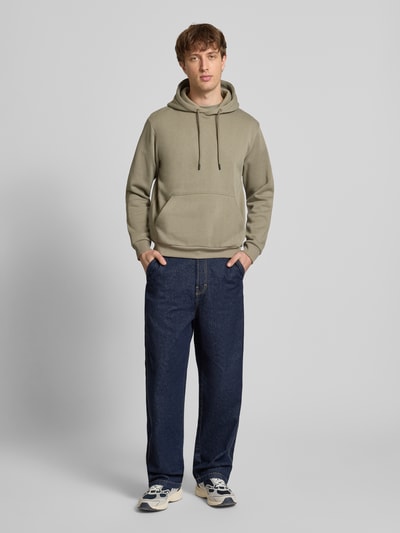 Männermodel trägt Hoodie mit Kapuze Modell 'BRADLEY' von Jack & Jones in Khaki, lockerer Schnitt, Baumwoll-Mix, Känguru-Tasche, Ganzkörperansicht von vorne.