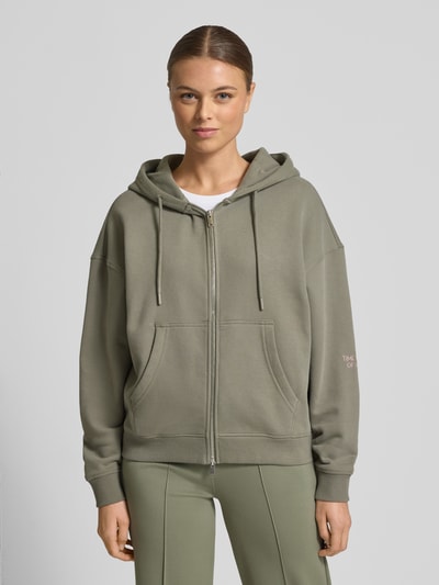 Frauenmodel trägt Oversized Sweatjacke mit Kapuze von Smith and Soul aus Baumwoll-Mix, Reißverschluss, Tunnelzug, Eingrifftaschen, gerippte Abschlüsse, graugrün, Ganzkörperansicht von vorne.