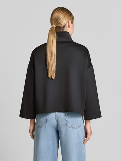 Vrouwenmodel draagt Relaxed Fit broek met opstaande kraag van comma, elastische materiaalmix, opgestikte zakken, ritssluiting, ruglengte 53 cm, borstwijdte 65 cm, mouwlengte 54 cm, Ganzkörperansicht Rückansicht.