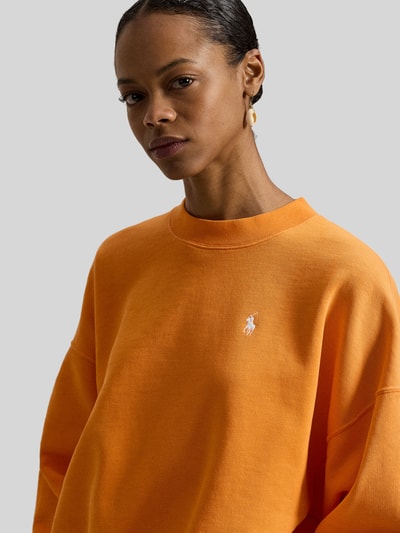 Frauenmodel trägt Oversized Sweatshirt aus Baumwoll-Mix von Polo Ralph Lauren in Orange, Logo-Stitching, Crew Neck, Nahaufnahme Oberkörper.
