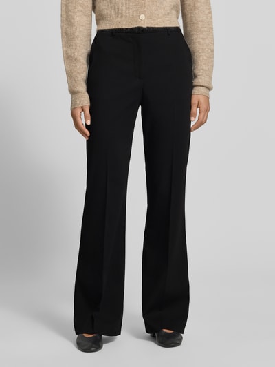 Frauenmodel trägt Flared Fit Hose mit Viskose-Anteil von MYON, schwarz, elastischer Material-Mix, Bügelfalten, Nahaufnahme Oberkörper.
