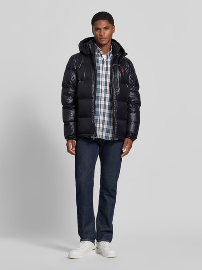 Männermodel trägt Regular Fit Steppjacke mit Zweiwege-Reißverschluss von Polo Ralph Lauren in Schwarz, glatte Struktur, Ganzkörperansicht von vorne, Herren Steppjacke von Polo Ralph Lauren.