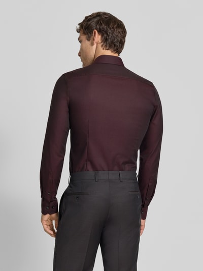 Männermodel trägt Super Slim Fit Businesshemd aus Baumwoll-Mix von OLYMP No. Six in Dunkelrot, glatte Struktur, Ganzkörperansicht Rückansicht.