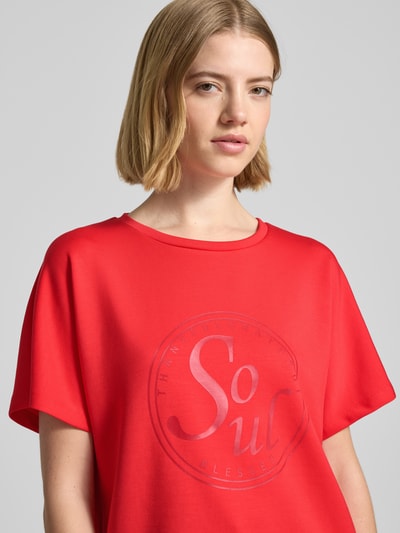 Frauenmodel trägt Damen T-Shirt mit Statement-Print Modell 'BANU' von Soyaconcept in Rot, Material-Mix mit Micromodal-Anteil, Relaxed-Fit, Rundhalsausschnitt, Nahaufnahme Oberkörper.