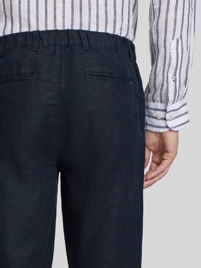 Männermodel trägt Leinenhose mit Eingrifftaschen Modell 'Pandrup' von Casual Friday in Dunkelblau, reine Leinenstruktur, Nahaufnahme Rückansicht, Regular Fit, Bundweite 42 cm, Innenbeinlänge 83 cm.