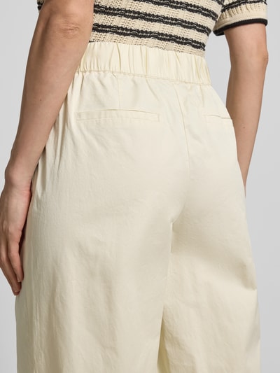 Kobieta nosi Regular Fit Culotte aus reiner Baumwolle od s.Oliver RED LABEL, kremowy twill, gładki wzór, kieszenie boczne, widok z tyłu, zbliżenie na biodra.