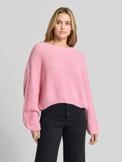 Vrouwenmodel draagt 'Oversized Strickpullover aus Leinen-Mix' van American Vintage in roze linnenmix, met lange mouwen, ronde hals, geribde zoom, relaxed oversized fit, ruglengte maat XS/S 56 cm, mouwlengte maat XS/S 54 cm, trendy textuur, volledig beeld van voren