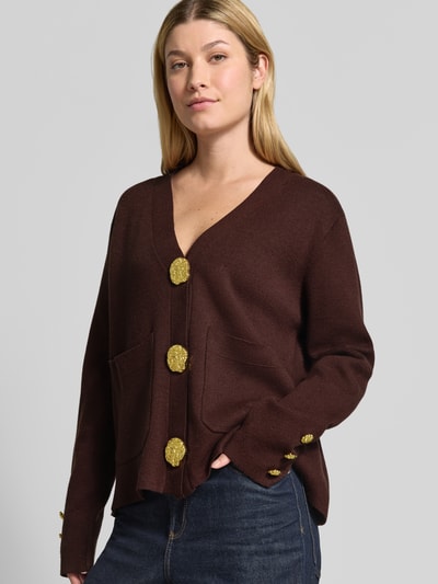 Vrouwenmodel draagt Strickjacke aus Viskose-Mix mit V-Ausschnitt van Apricot, donkerbruin, viscosemix, regular fit, V-hals, knoopsluiting, opgestikte zakken, ruglengte maat S 57 cm, mouwlengte maat S 63 cm, goudkleurige knopen, Ganzkörperansicht van voren