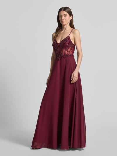 Frauenmodel trägt Abendkleid mit floralem Ziersteinbesatz von Laona in Bordeaux mit Spaghettiträgern, Semitransparente-Optik, taillierte Passform, Ganzkörperansicht von vorne.