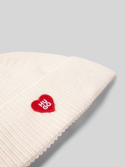 Produktfoto, Beanie aus Schurwoll-Mix Modell 'SENTIALY_HAT' von HUGO, kremowy rippstrick, szeroki mankiet, czerwony patch z logo, minimalistyczny styl