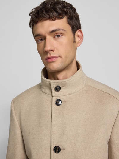 Männermodel trägt Regular Fit Mantel aus Schurwoll-Mix mit Kaschmir-Anteil Modell 'MARON' von JOOP! Collection, sandfarben, Nahaufnahme Oberkörper, Stehkragen, Knopfleiste, Kontext: Herren Mantel, Eingrifftaschen, Maße Größe 50