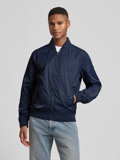 Männermodel trägt Regular Fit Bomberjacke mit Stehkragen von s.Oliver RED LABEL, navy, unifarben, seitliche Pattentaschen, Ganzkörperansicht von vorne.