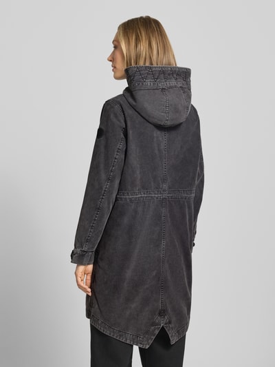 Kobiece model nosi Parka mit Kapuze und Pattentaschen Modell 'FREYA' von khujo z bawełny, krój relaxed fit, kolor ciemnoszary, tył z tunel, kieszenie z patką, długość tyłu w rozmiarze S: 94 cm, szerokość ramion w rozmiarze S: 41 cm, szerokość klatki piersiowej w rozmiarze S: 53 cm, długość rękawów w rozmiarze S: 58 cm; całkowita sylwetka, widok z tyłu.
