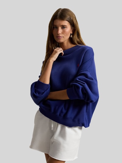 Vrouwenmodel draagt Regular Fit Sweatshirt aus Baumwoll-Mix van Polo Ralph Lauren in effen blauw met logo-detail, sweatstof, ronde hals, geribde boorden, long sleeves, overzicht, close-up bovenlichaam.